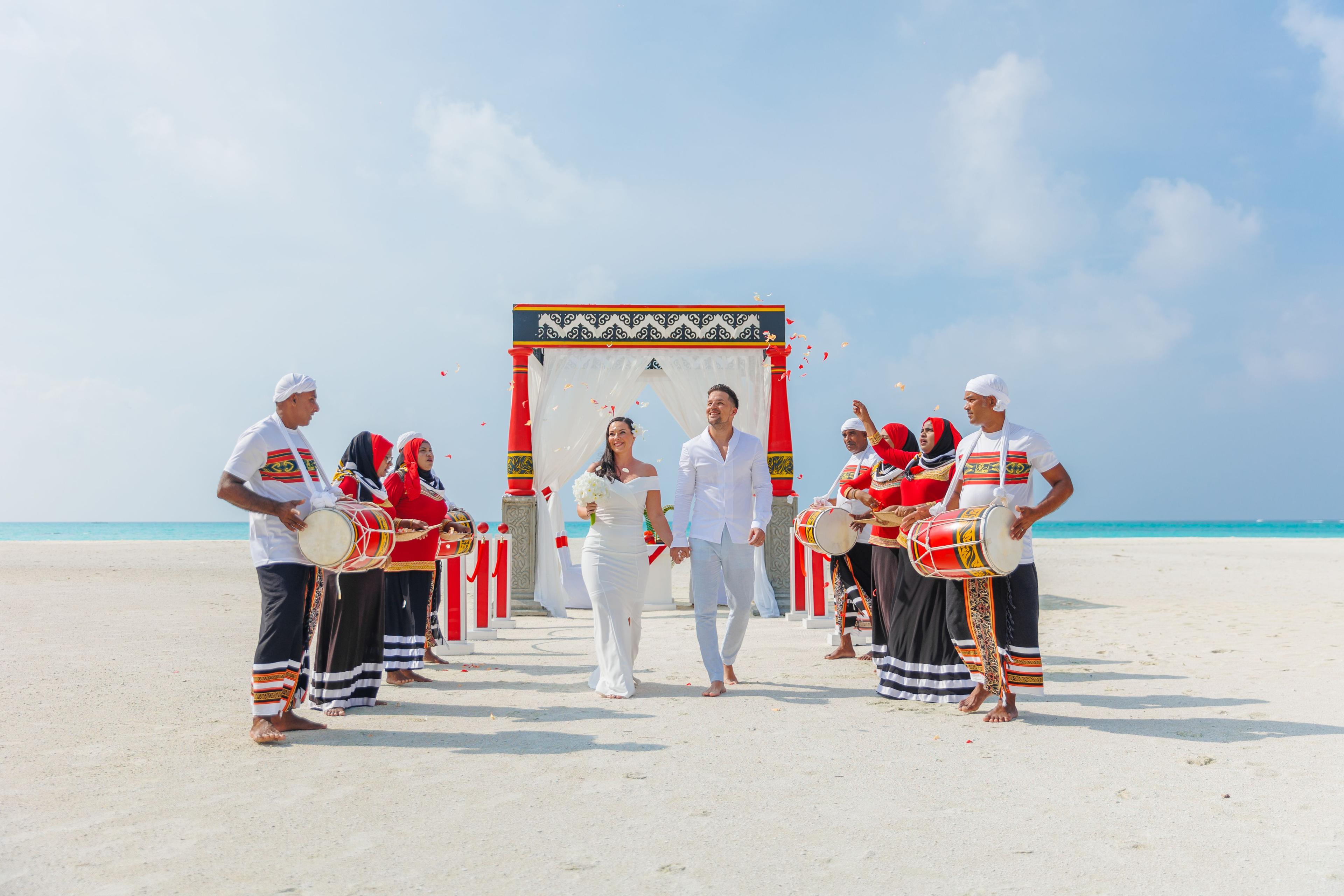 couple walking from a beach wedding alter in maldives