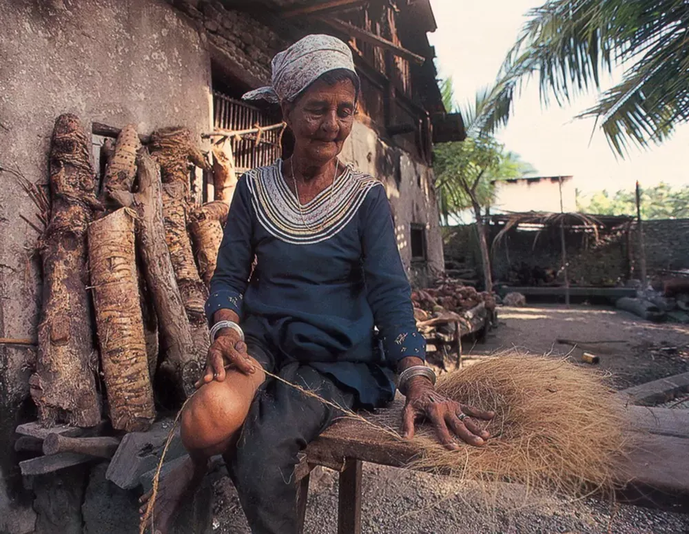 An old woman in the Maldives weaving coir rope